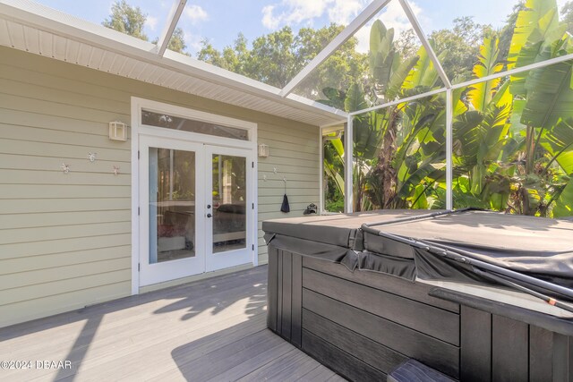 deck with a lanai, french doors, and a hot tub