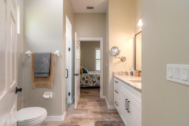 bathroom featuring toilet, vanity, and hardwood / wood-style flooring