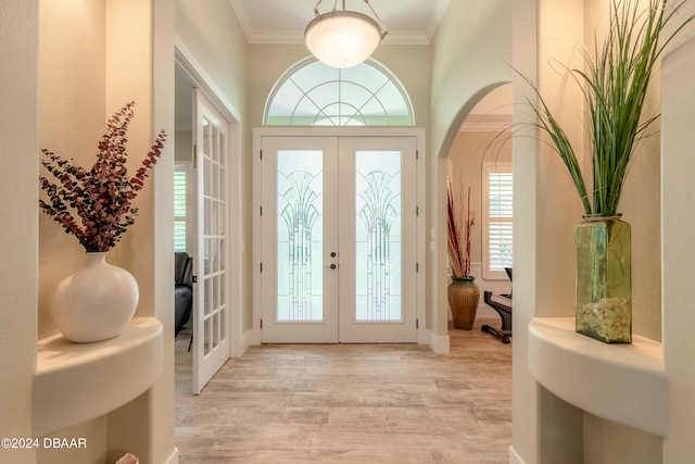 doorway with ornamental molding, french doors, and light hardwood / wood-style floors