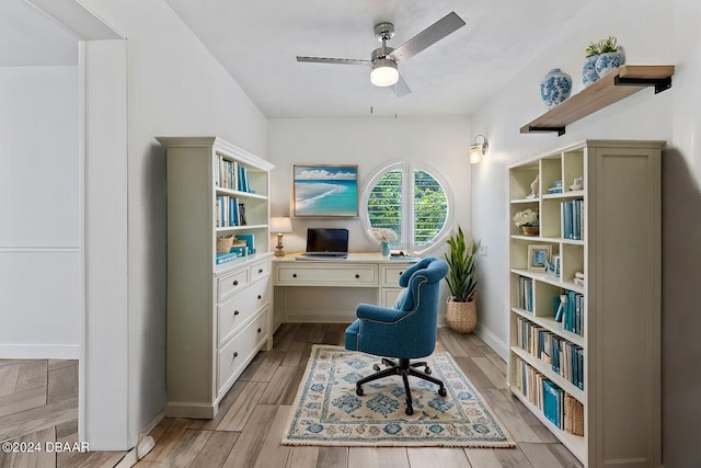 home office with light hardwood / wood-style flooring and ceiling fan