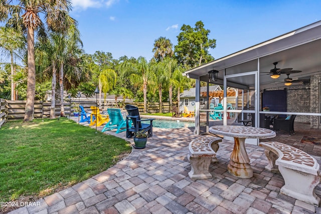 view of patio with a sunroom, ceiling fan, and a fenced in pool