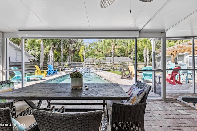 sunroom with ceiling fan, plenty of natural light, and a swimming pool