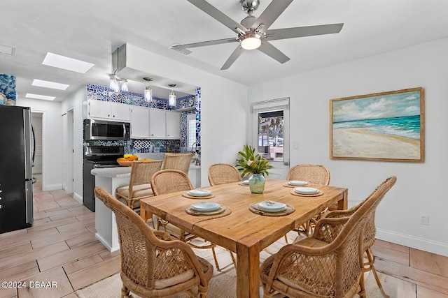 dining area with a skylight and ceiling fan