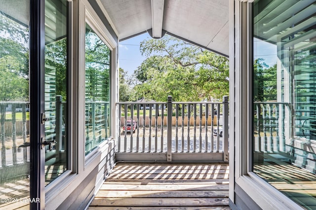 unfurnished sunroom with vaulted ceiling with beams