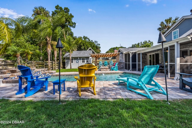 view of swimming pool with an outbuilding, a patio, and a sunroom