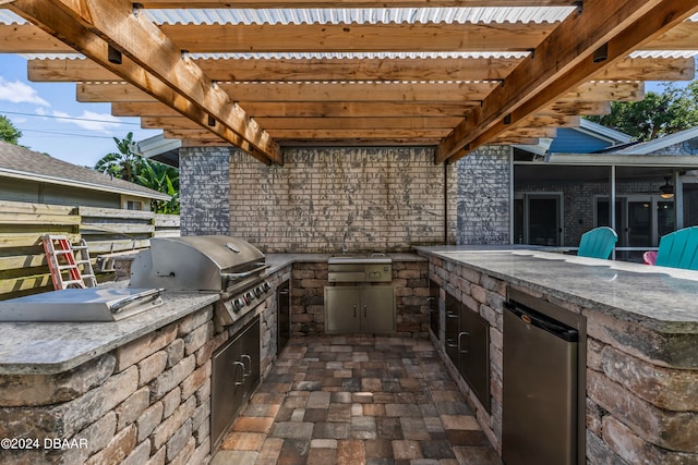 view of patio featuring an outdoor kitchen, grilling area, and a pergola