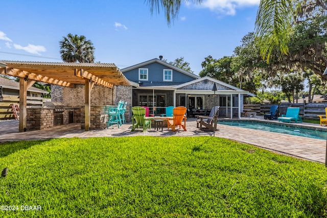 back of property with a pergola, a patio area, a lawn, and an outdoor kitchen