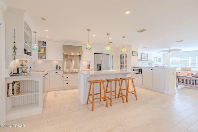 kitchen with a kitchen breakfast bar, white cabinetry, a kitchen island, and stainless steel appliances