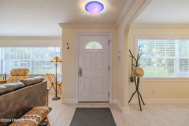 foyer entrance featuring a healthy amount of sunlight, light hardwood / wood-style floors, and ornamental molding