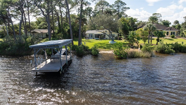 dock area with a lawn and a water view