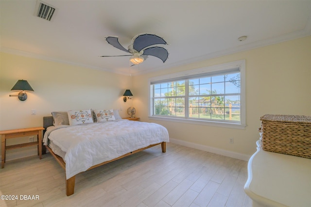 bedroom with ceiling fan, crown molding, and light hardwood / wood-style flooring