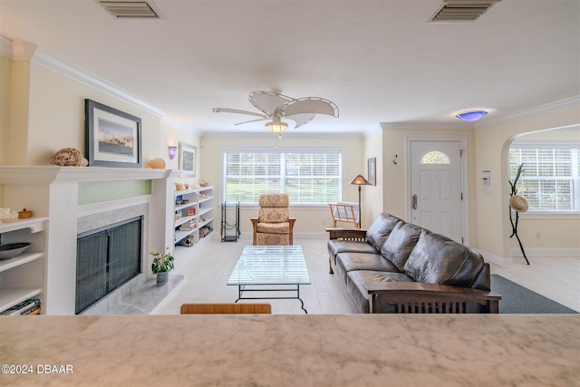 1949 Bayview Dr, New Smyrna Beach, FL 32168 - living room featuring ornamental molding, a high end fireplace, baseboards, and arched walkways