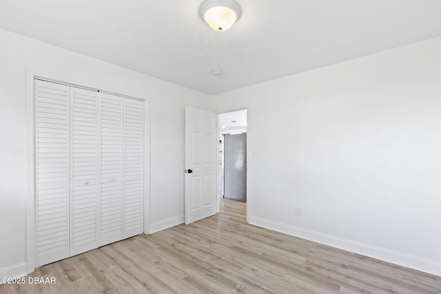 unfurnished bedroom with a closet and light wood-type flooring