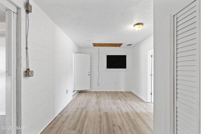 corridor with light hardwood / wood-style floors