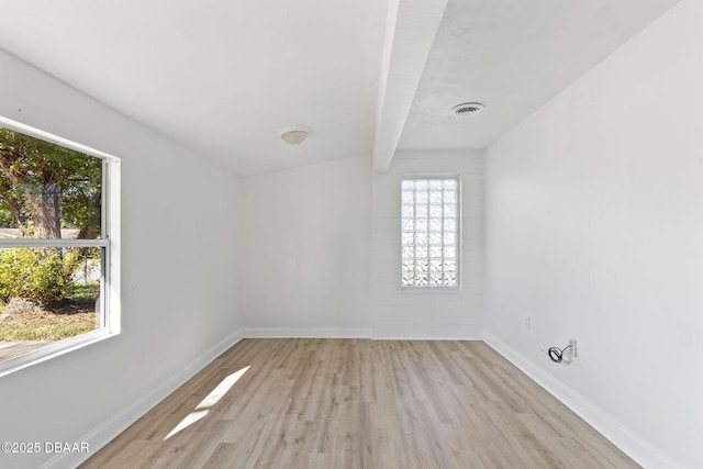 empty room featuring beam ceiling and light wood-type flooring