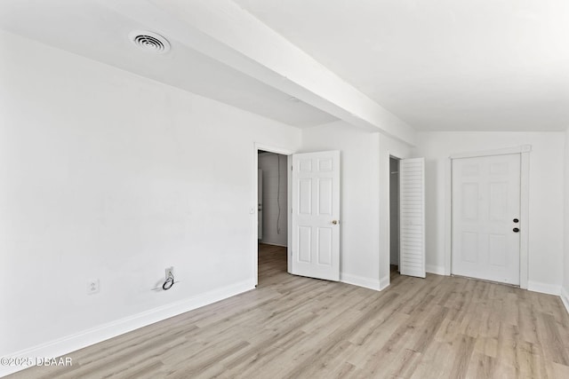 unfurnished bedroom with light hardwood / wood-style floors and lofted ceiling