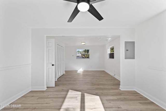 empty room featuring electric panel, light hardwood / wood-style flooring, and ceiling fan