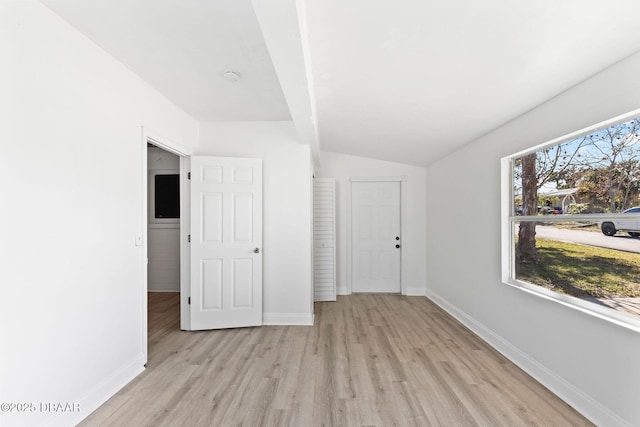 unfurnished room with light hardwood / wood-style flooring, a wealth of natural light, and lofted ceiling