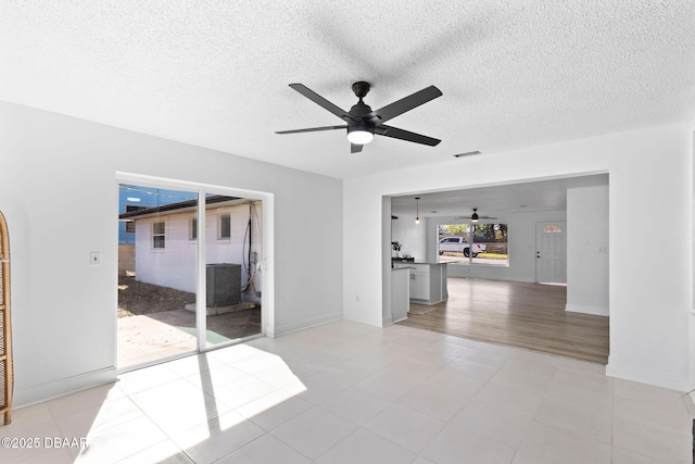 tiled empty room featuring a textured ceiling and ceiling fan