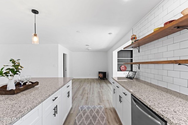 kitchen featuring white cabinets, light hardwood / wood-style flooring, stainless steel dishwasher, tasteful backsplash, and light stone counters