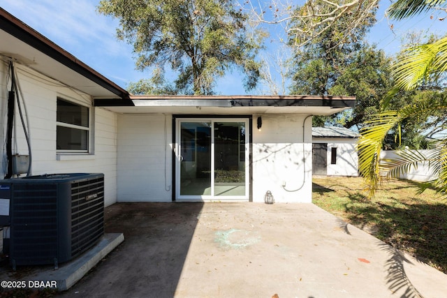 rear view of house featuring central AC unit, a patio area, and a lawn