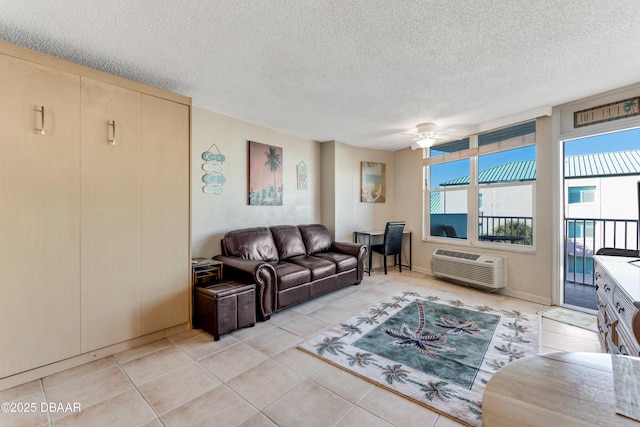 living room featuring a wall unit AC, ceiling fan, light tile patterned floors, and a textured ceiling