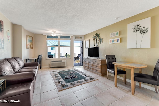 living room featuring light tile patterned floors, a textured ceiling, an AC wall unit, and ceiling fan