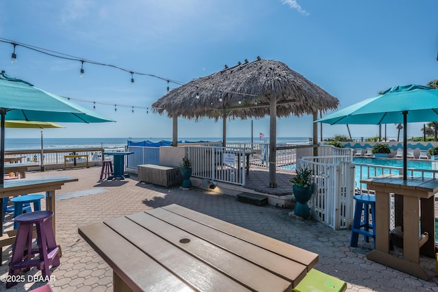 exterior space with a patio area, a community pool, and a water view