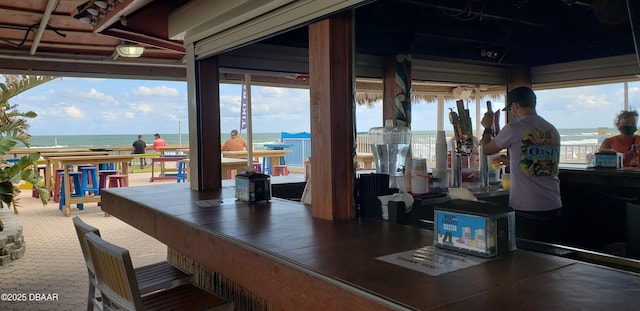 view of patio with a water view and a bar