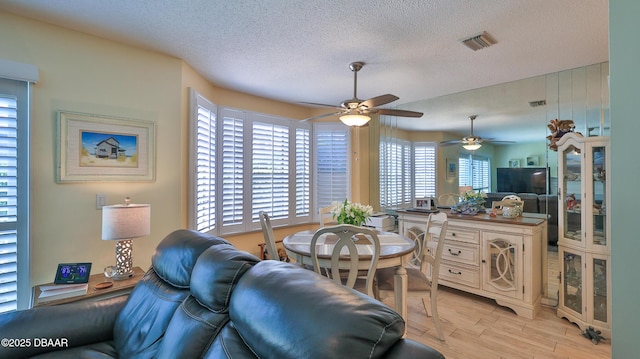 2942 Sea Oats Cir, Daytona Beach, FL 32118 - living area with visible vents, a textured ceiling, a ceiling fan, and light wood-style flooring