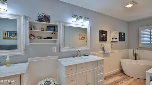2942 Sea Oats Cir, Daytona Beach, FL 32118 - full bath with a freestanding tub, wainscoting, vanity, and wood finished floors