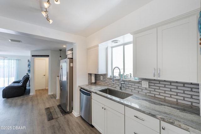 59 Arroyo Pkwy, Ormond Beach, FL 32174 - kitchen with appliances with stainless steel finishes, tasteful backsplash, white cabinets, and light stone counters