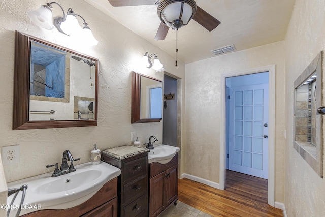 59 Arroyo Pkwy, Ormond Beach, FL 32174 - bathroom featuring wood finished floors, two vanities, ceiling fan, and a textured wall