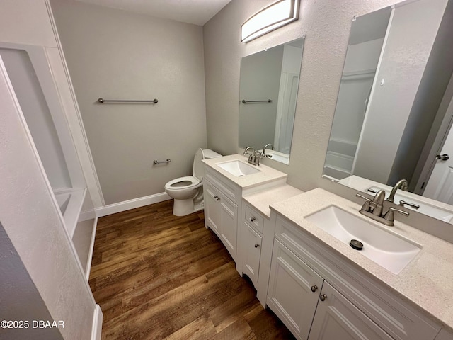 bathroom featuring wood-type flooring, vanity, and toilet