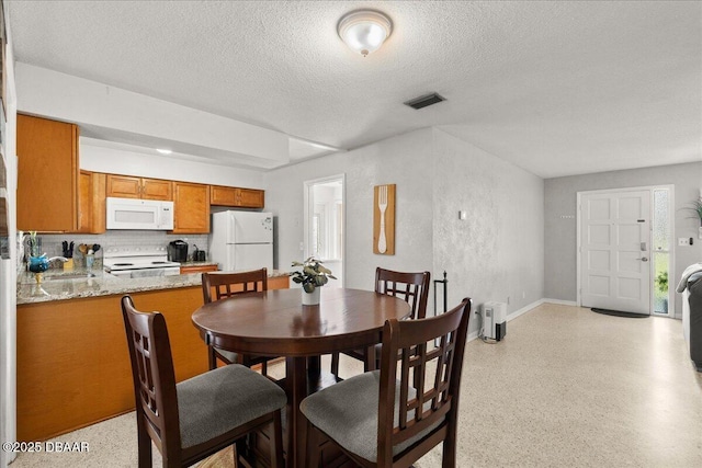 211 Fox Pl, Port Orange, FL 32127 - dining area with a textured ceiling, dark aggregate flooring, and a textured wall