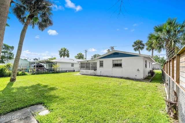 211 Fox Pl, Port Orange, FL 32127 - back of house featuring a detached carport, a fenced backyard, a sunroom, and concrete block siding
