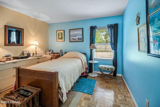 bedroom with baseboards and a textured ceiling