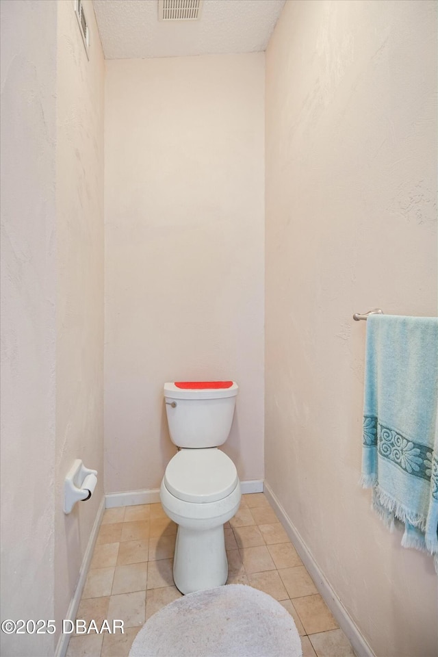 bathroom with tile patterned floors, visible vents, baseboards, and toilet