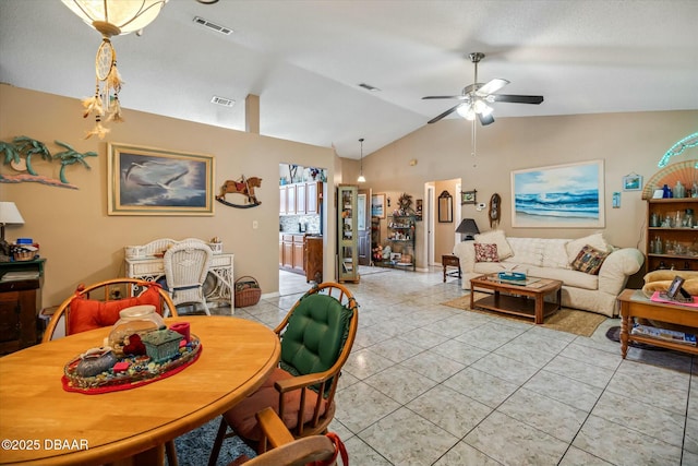 dining area featuring visible vents, ceiling fan, light tile patterned flooring, and vaulted ceiling