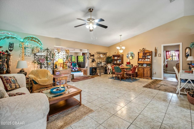 living area with light tile patterned floors, ceiling fan with notable chandelier, and vaulted ceiling