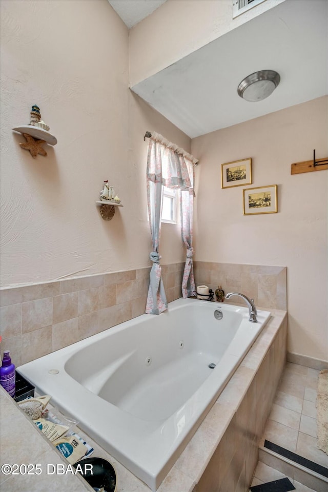 full bath featuring tile patterned floors and a tub with jets