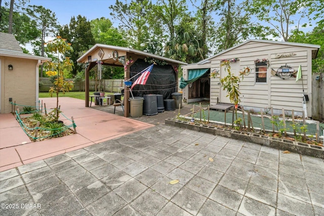 view of patio with an outdoor structure and fence