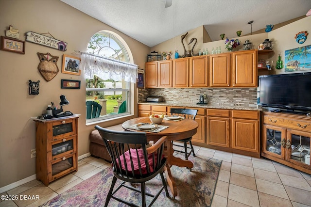 kitchen featuring decorative backsplash, light tile patterned flooring, vaulted ceiling, and a textured ceiling