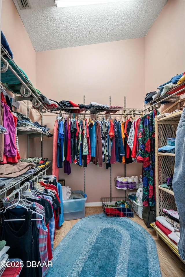 walk in closet with wood finished floors