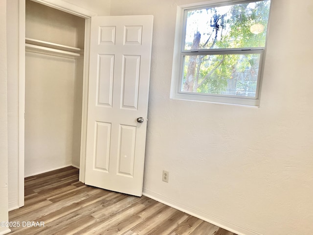 unfurnished bedroom featuring hardwood / wood-style floors and a closet