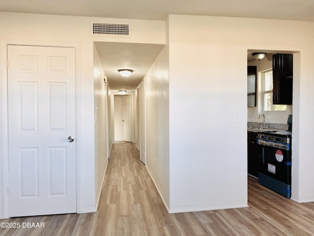 hall featuring light hardwood / wood-style flooring and sink