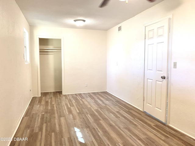 unfurnished bedroom featuring a textured ceiling, hardwood / wood-style flooring, and ceiling fan