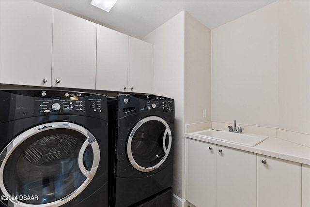 laundry area featuring washing machine and dryer, sink, and cabinets