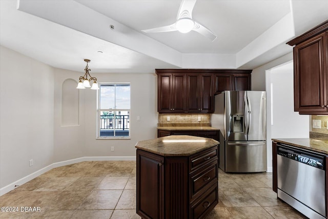 kitchen with backsplash, dark brown cabinets, a kitchen island, ceiling fan with notable chandelier, and appliances with stainless steel finishes