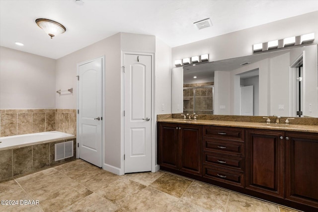 bathroom featuring tile patterned flooring, vanity, and separate shower and tub